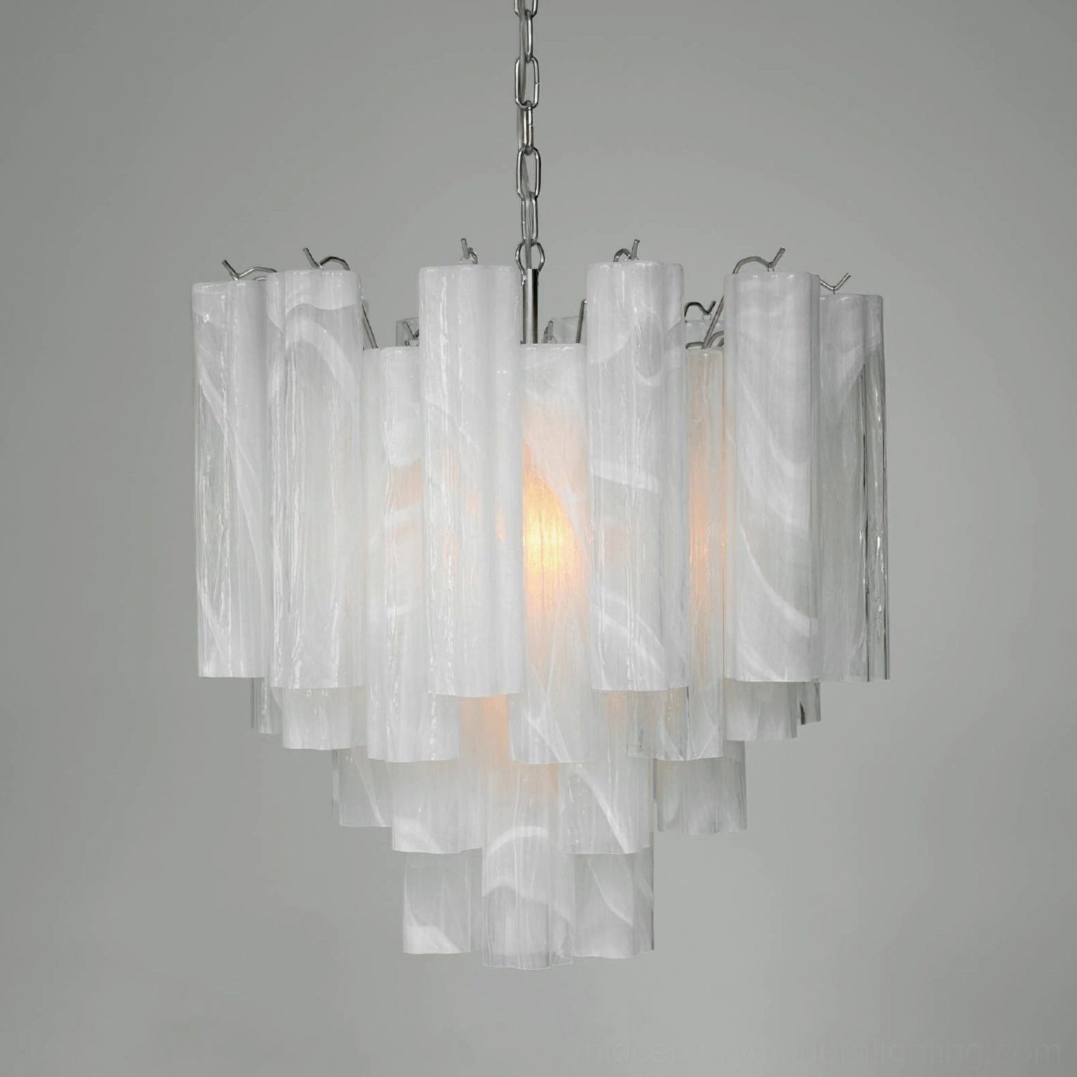 Modern tiered glass chandelier with layered white frosted tubes and polished silver hardware, overhead view with warm illumination