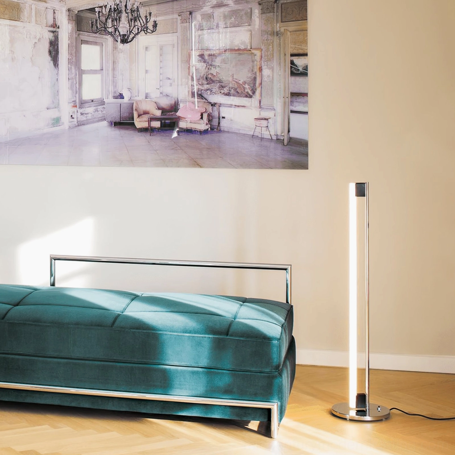 Minimalist chrome tube floor lamp beside teal tufted bench creating soft warm lighting in modern living space
