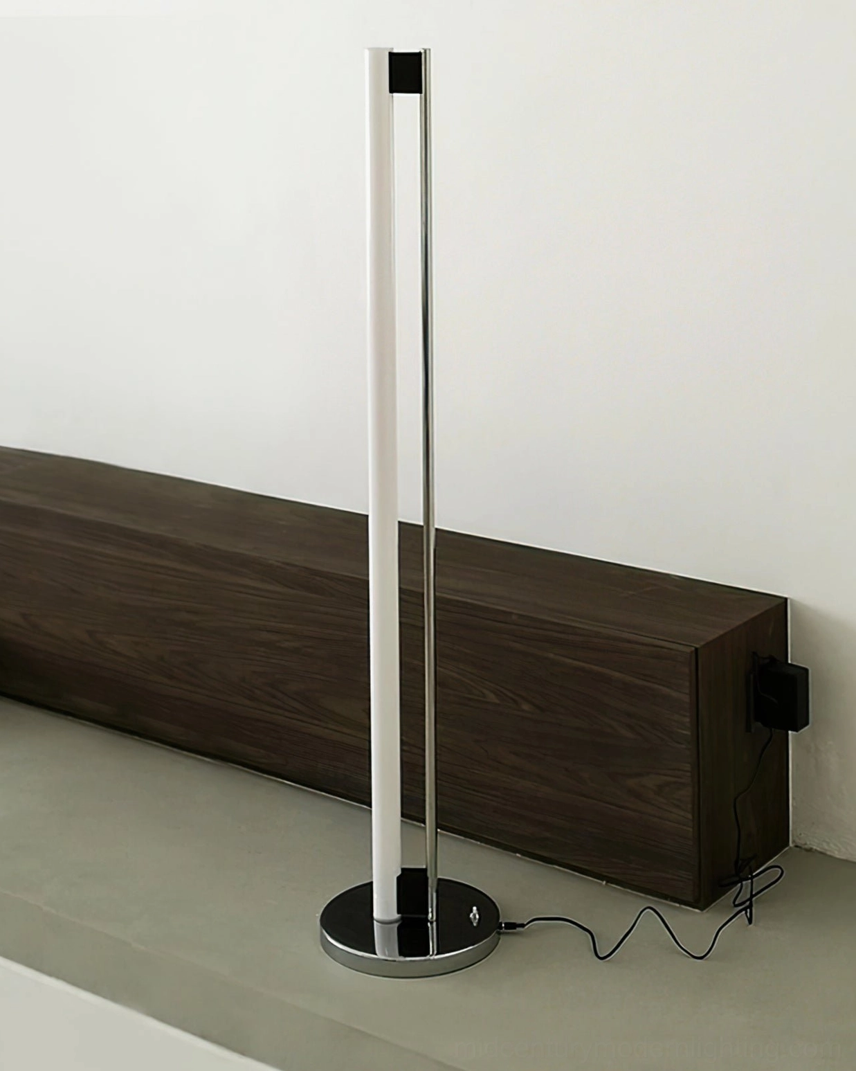 Minimalist tube floor lamp in monochromatic living room with sleek furniture and uncluttered aesthetic