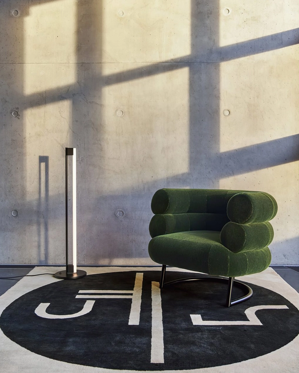 Chrome tube floor lamp with warm ambient glow in contemporary living space with design-forward decor