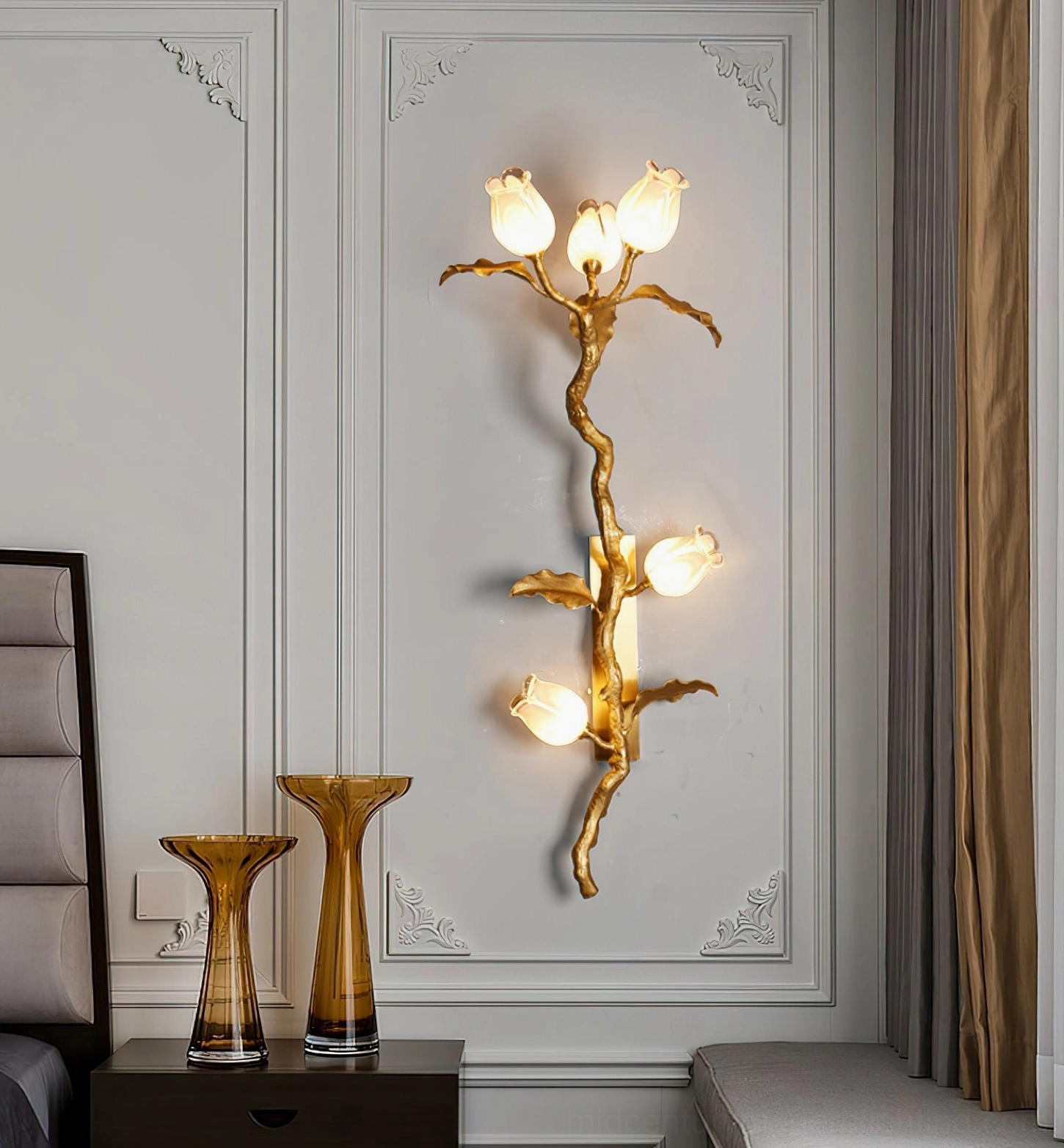 Tulip Branch Brass Wall Sconce in bedroom bedside area with decorative glass vases and neutral paneled walls creating warm ambiance