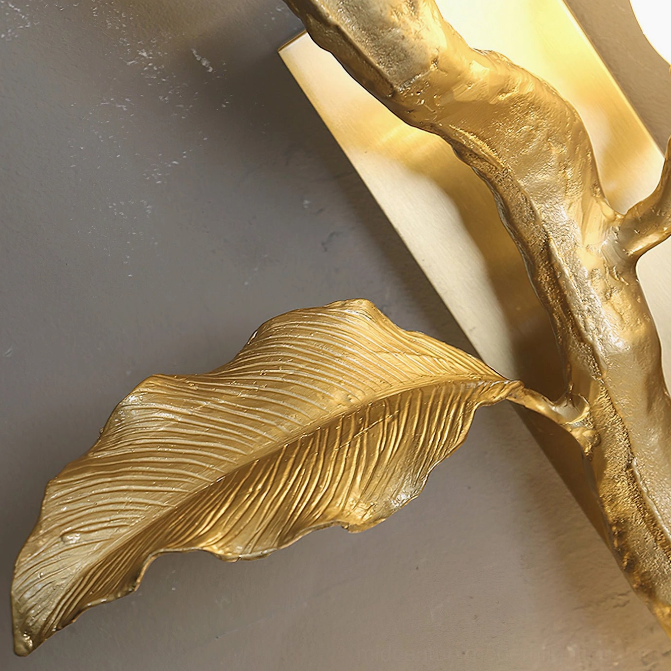 Macro side view of Tulip Branch hardware showing textured polished brass metal construction and organic leaf design details