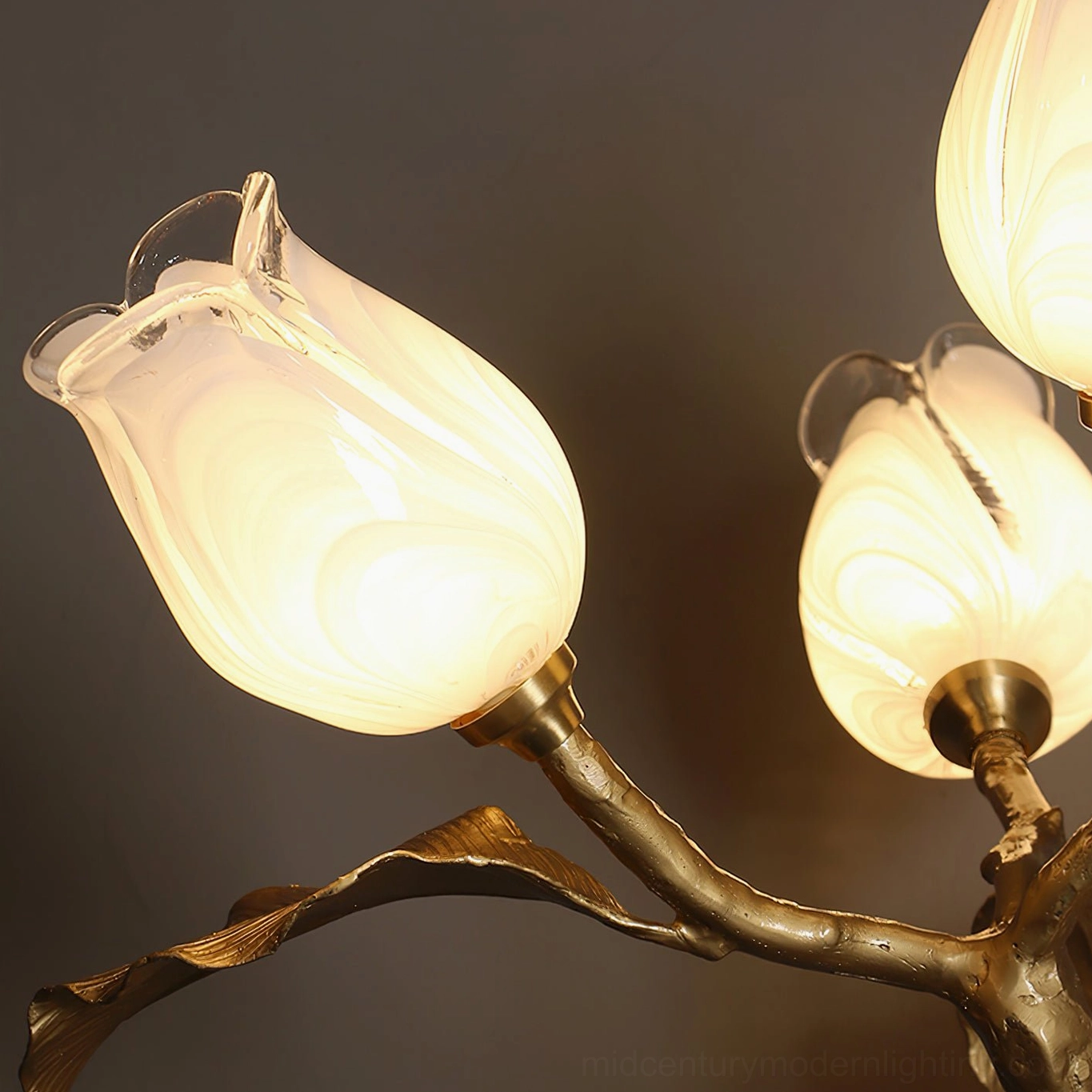 Close-up macro detail of Tulip Branch showing swirled frosted glass tulip shades and textured hand-cast brass branches