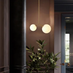 Twis brass pendant light with warm gold metal frame and frosted white glass globes in upscale residential entryway