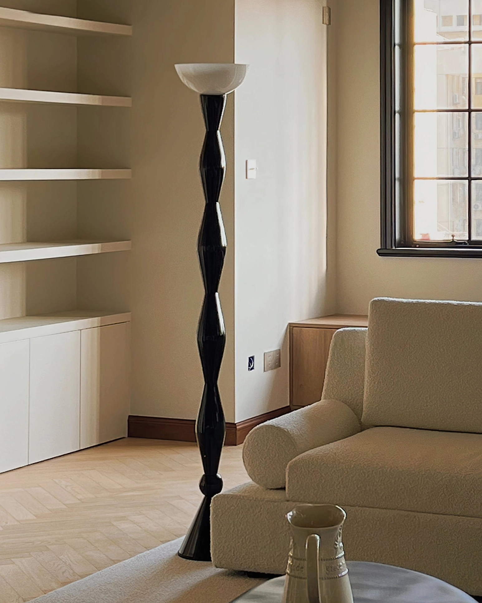Close-up detail of twisted black metal column and white glass shade on mid-century torchiere floor lamp