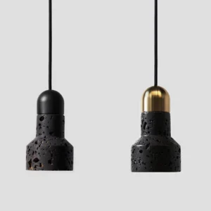 Two black hole stone pendant lights with mixed metal finishes, minimalist studio display showing stone texture variation