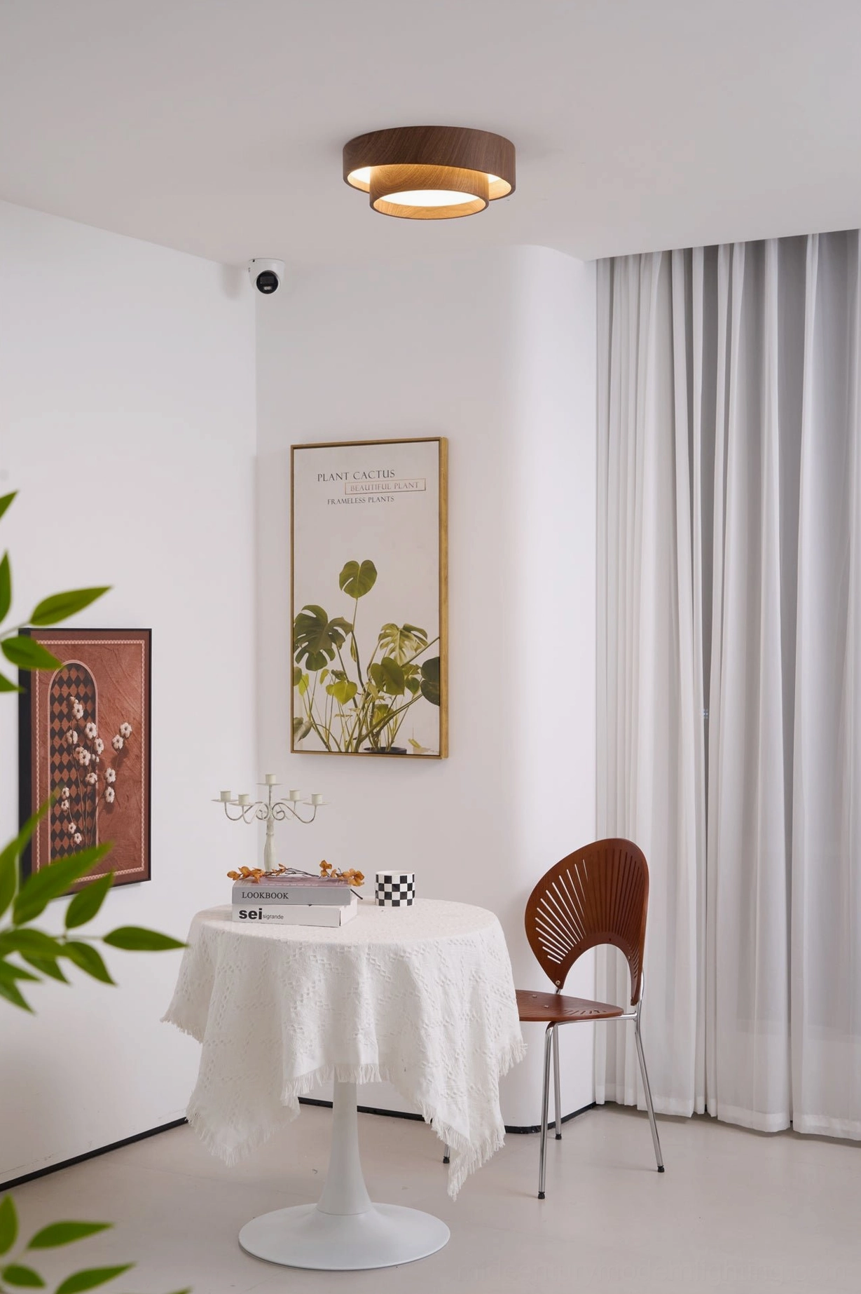 Vaako wood grain ceiling lamp above minimalist dining nook with white round table and modern cafe-inspired setting