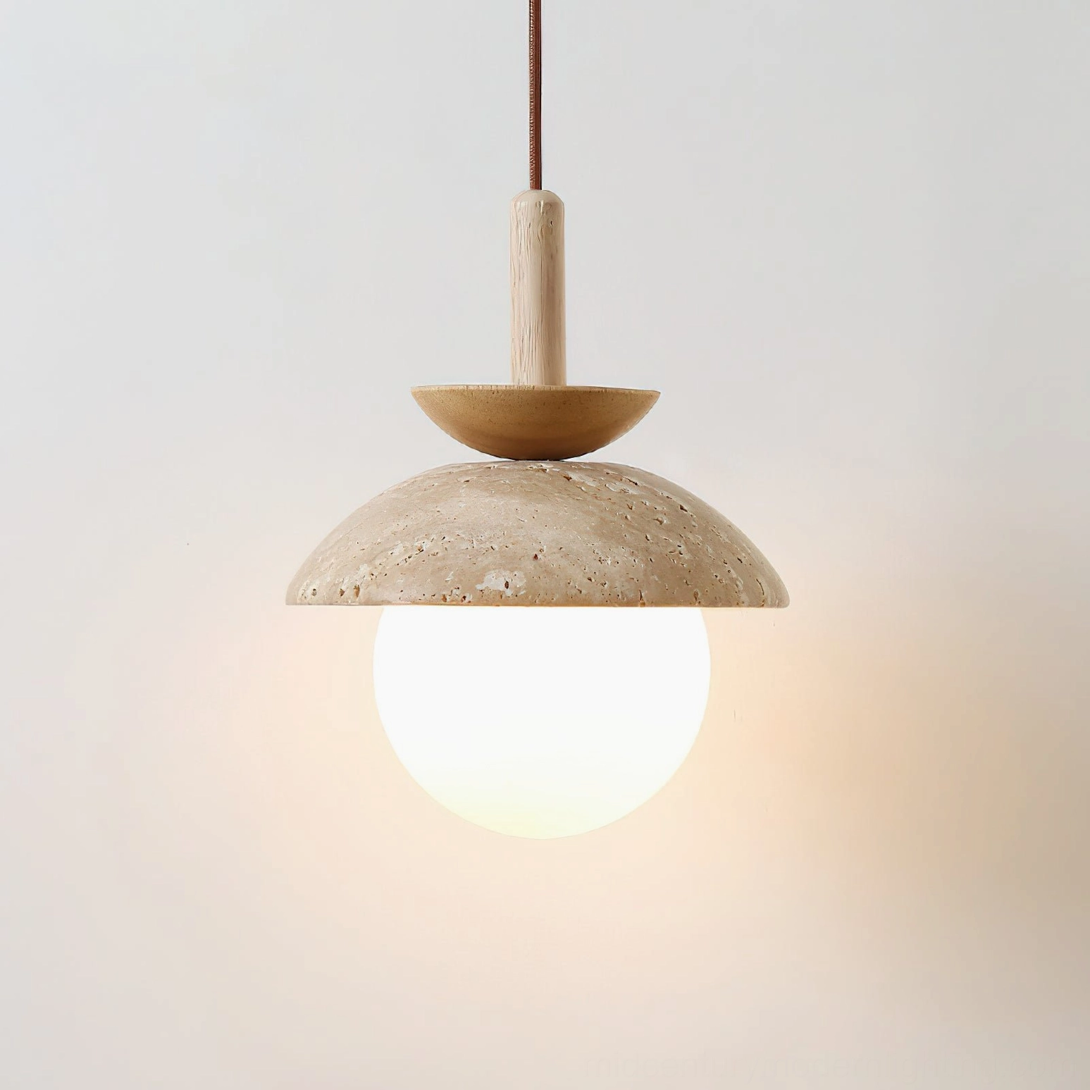 Close-up of Valerie pendant light showing porous travertine stone texture and frosted glass bulb