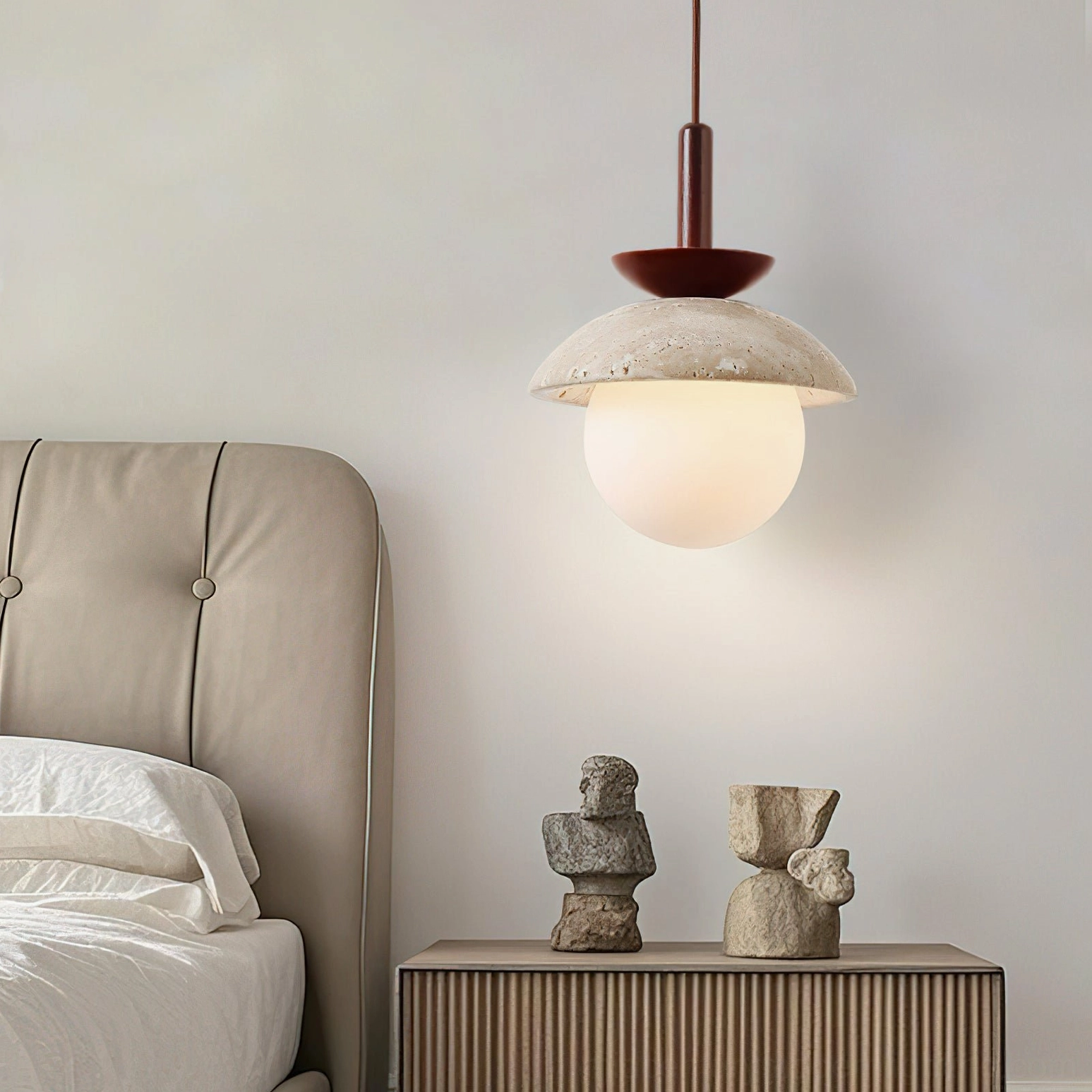 Valerie pendant light in dark wood finish with beige travertine shade in bedroom corner with stone ornaments and accent decor