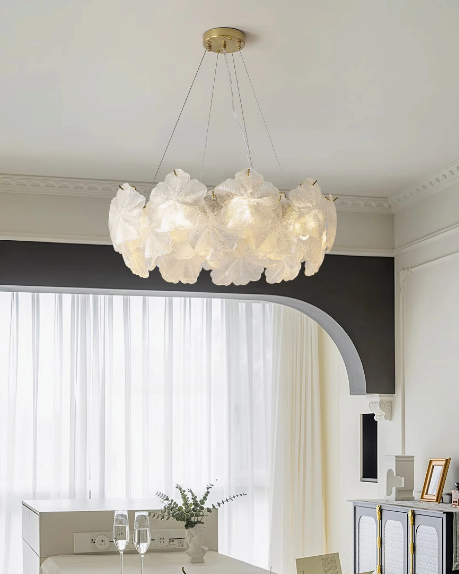 Two-tier Valery chandelier front view, arched sheer curtain window, dark accent trim