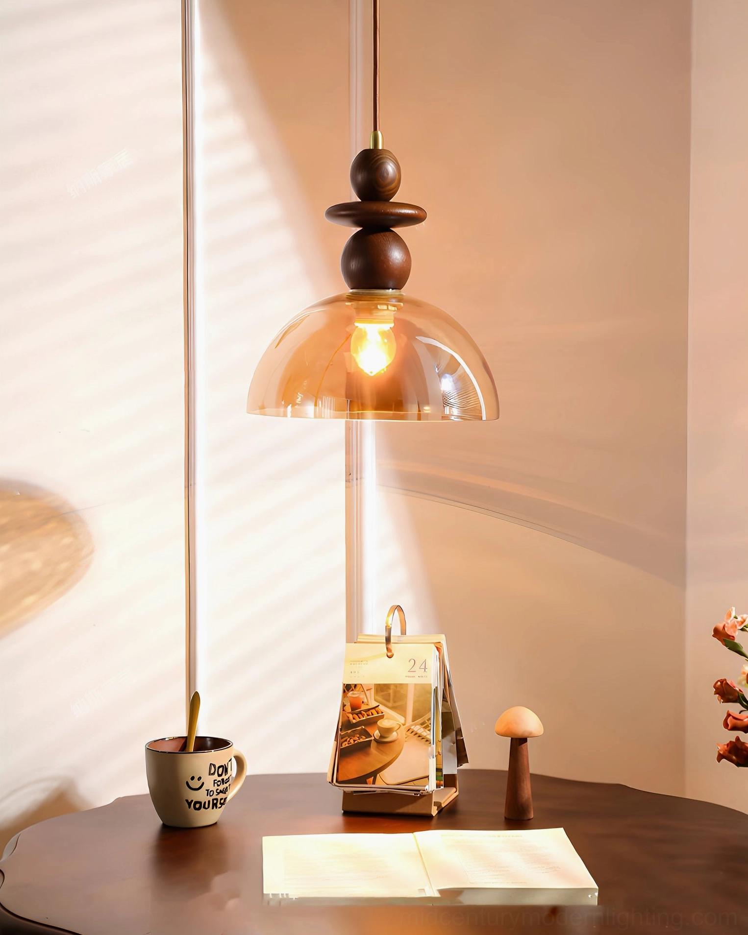 Valeska amber pendant light three-quarter angle with wooden table and soft sunlight through blinds