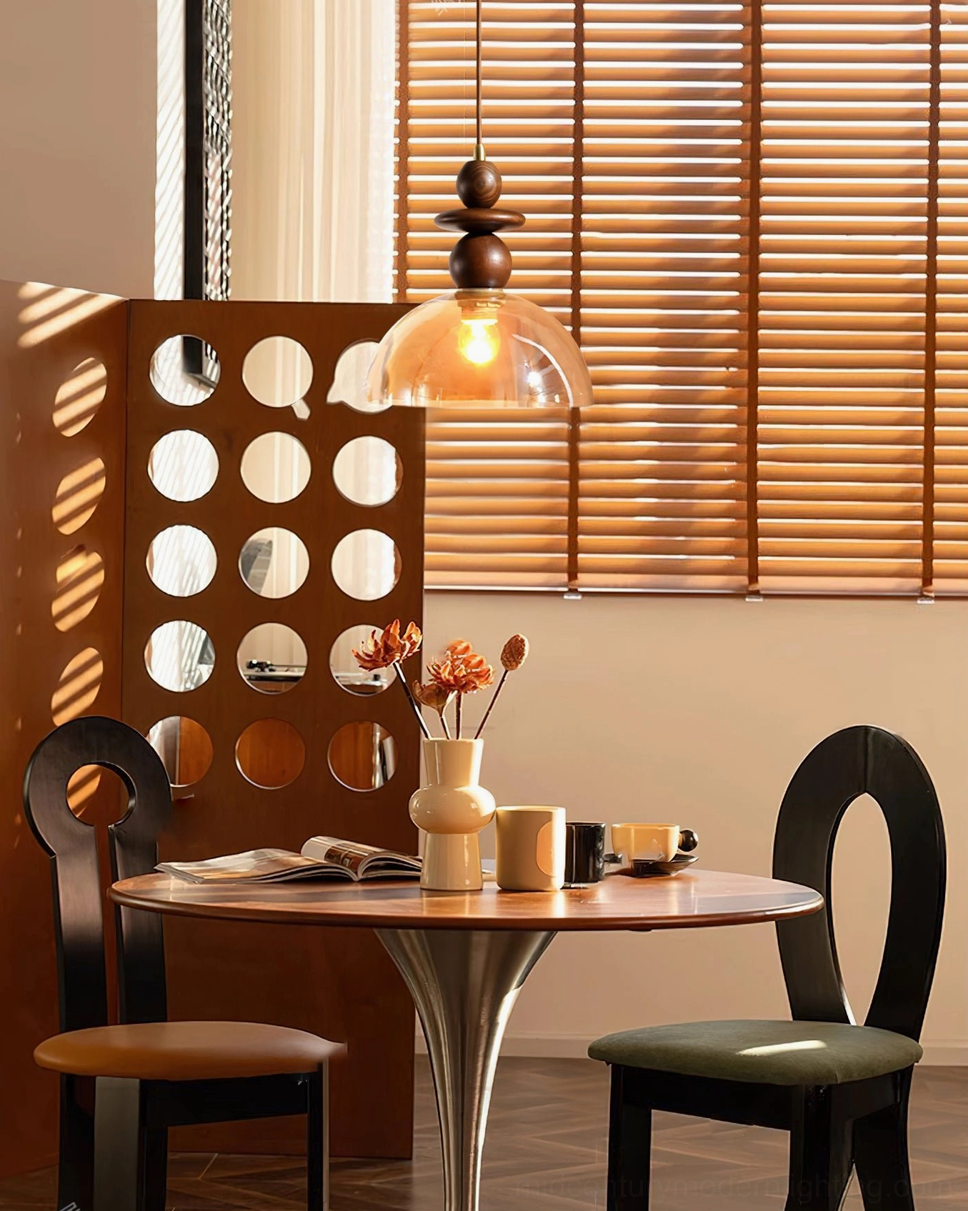 Valeska pendant light hanging above dining area with louvered window and wooden partition screen
