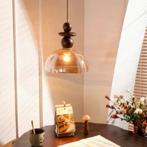 Valeska pendant light suspended over wooden dining table with warm ambient lighting and louvered window background