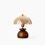 Valeska mushroom table lamp front view with walnut base, brass collar, and amber glass dome on white background