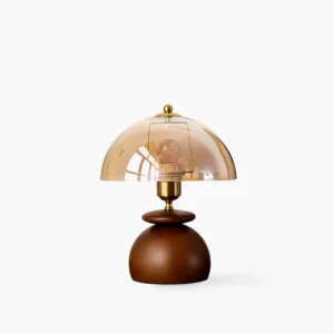 Valeska mushroom table lamp front view with walnut base, brass collar, and amber glass dome on white background