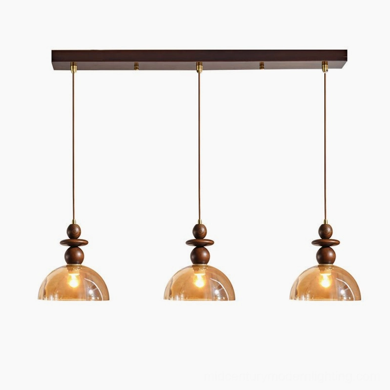 Valeska 3-light pendant configuration with amber glass and walnut wood in dining room setting