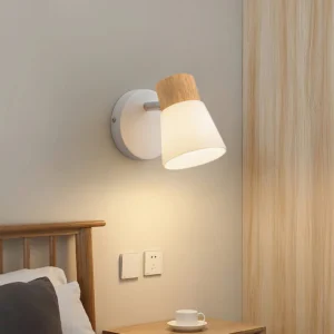 Valku single-head wall lamp installed above wooden bed frame in contemporary bedroom, warm ambient lighting