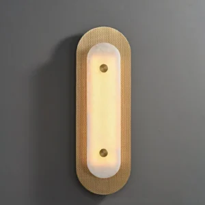 Vance Wall Sconce installed on dark grey wall, showing warm LED glow through translucent alabaster shade