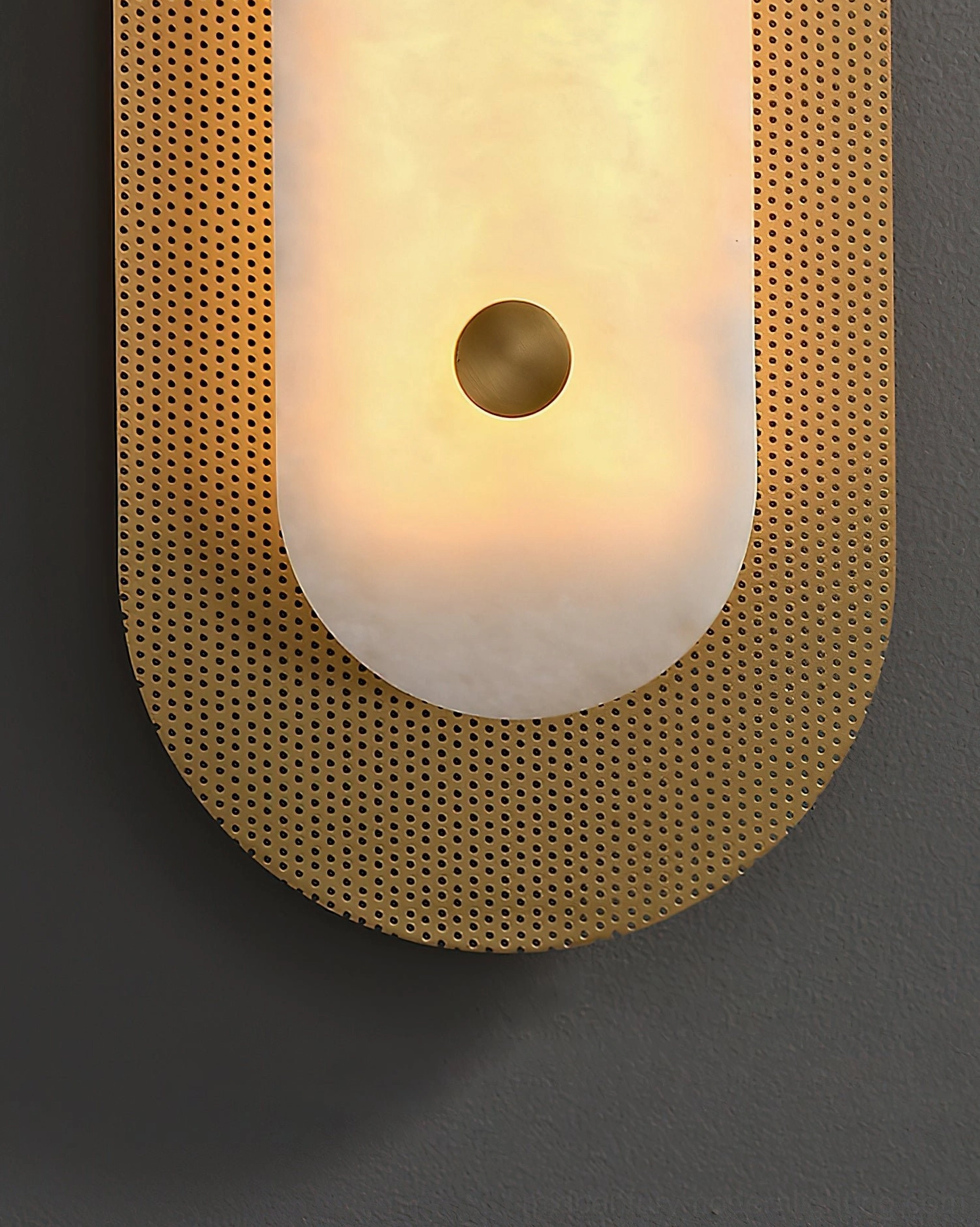 Extreme close-up of Vance Wall Sconce curved perforated brass frame and brass accent knob