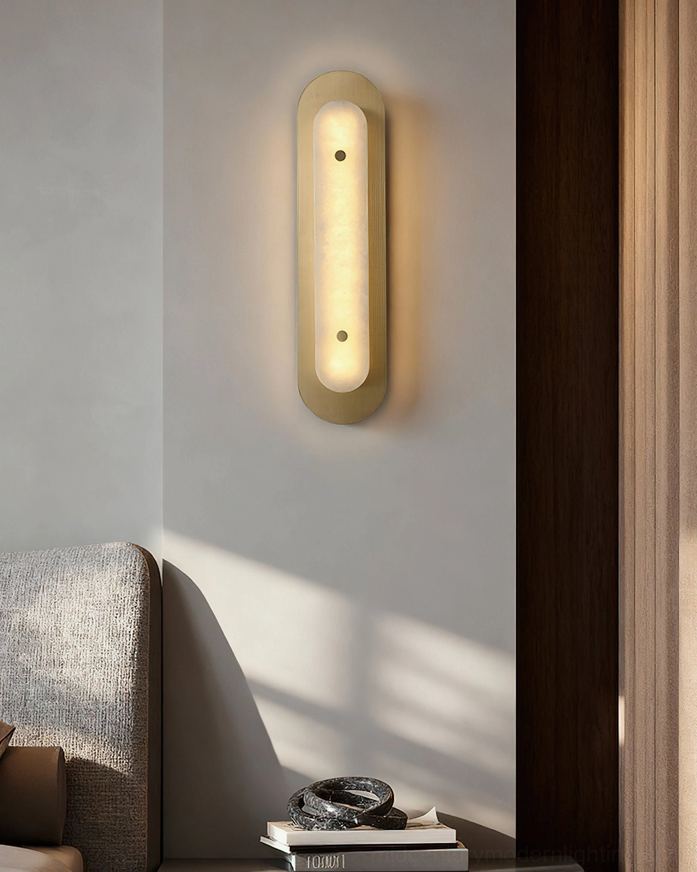 Vertical Vance Wall Sconce in minimalist living room with stacked books and warm glow