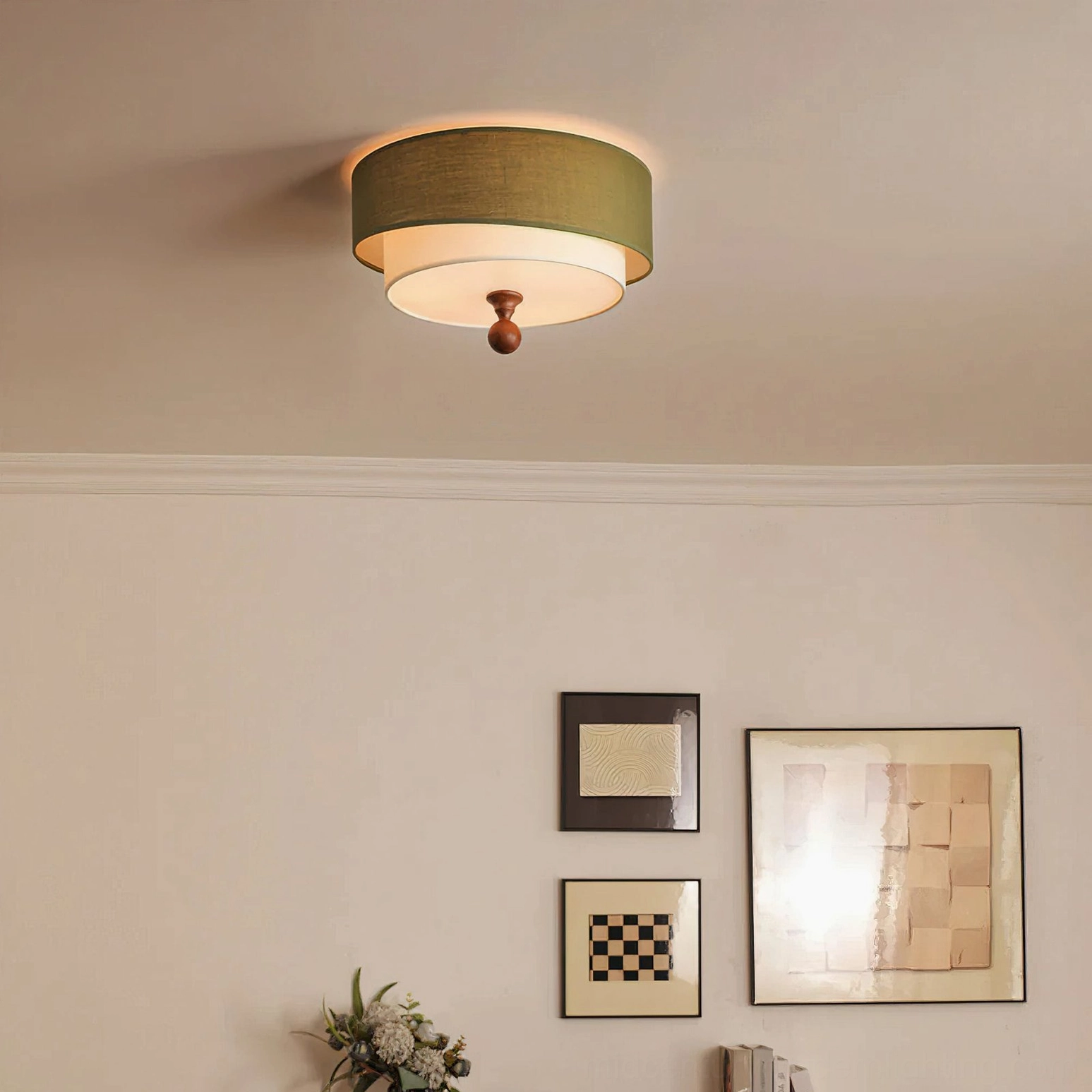 Vanelia ceiling lamp in olive green shade installed in minimalist room, low-angle ceiling view displaying dual-layer fabric design, wood finial, and coordinating wall decoration