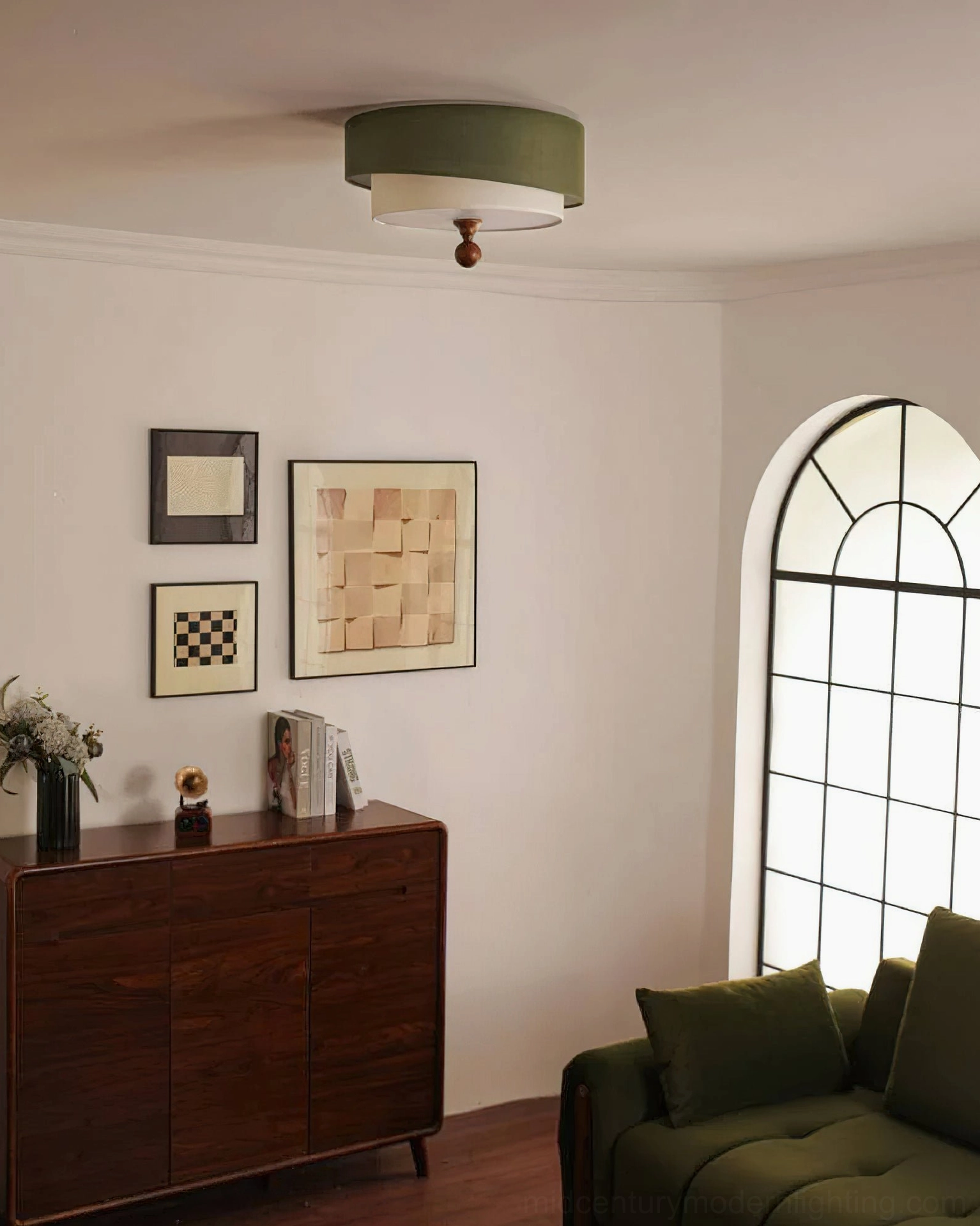 Vanelia mid-century lamp in olive green displayed in residential living room corner, coordinating with dark wood furniture and green upholstered sofa decor