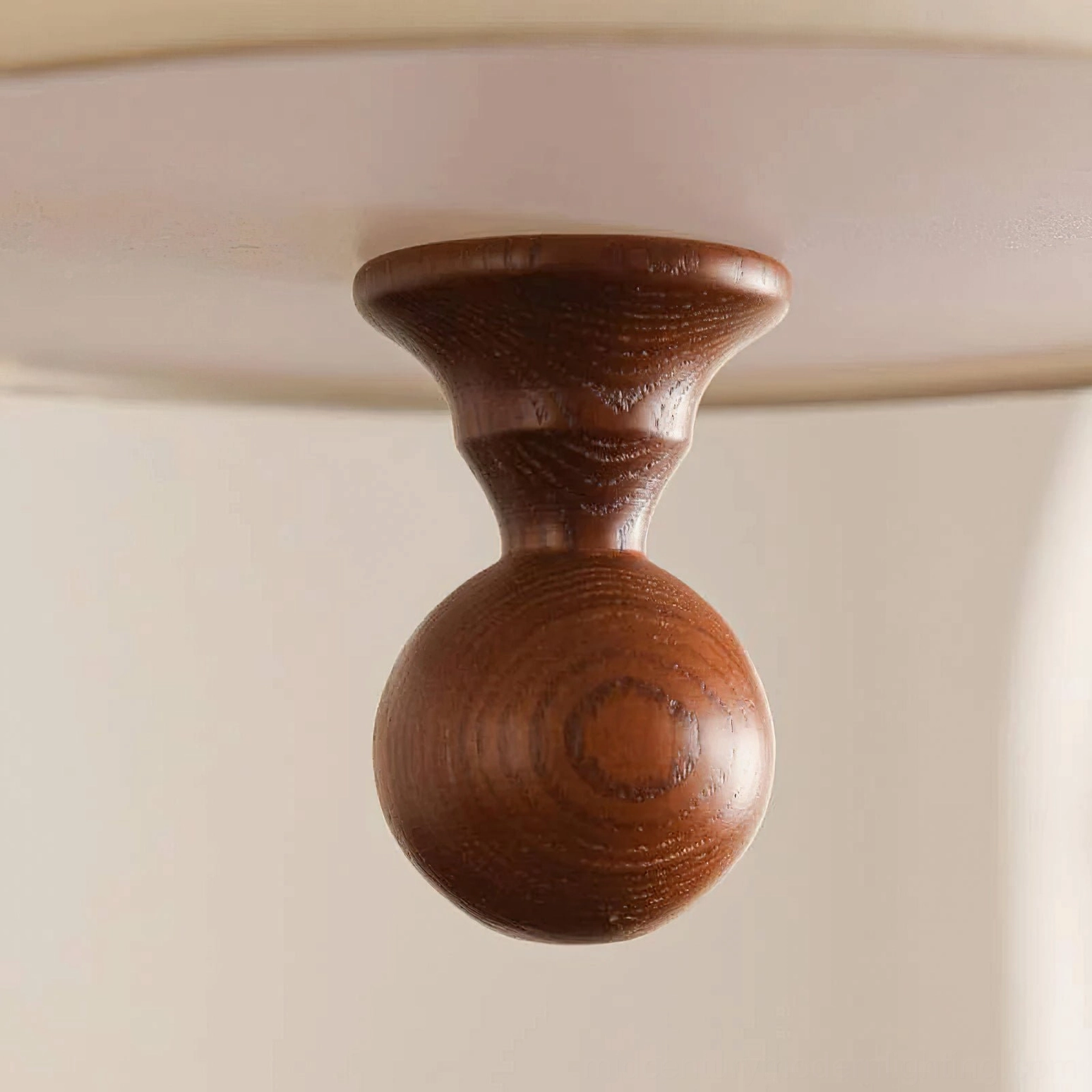 Vanelia ceiling lamp wooden finial and mounting detail, macro overhead close-up showing hand-turned walnut wood construction with natural grain and carved craftsmanship