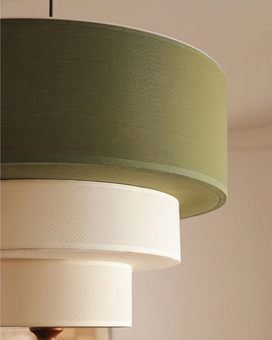 Vanelia pendant lamp overhead view showing tri-tier fabric layering, warm light diffusion, and walnut wood finial in modern dining context