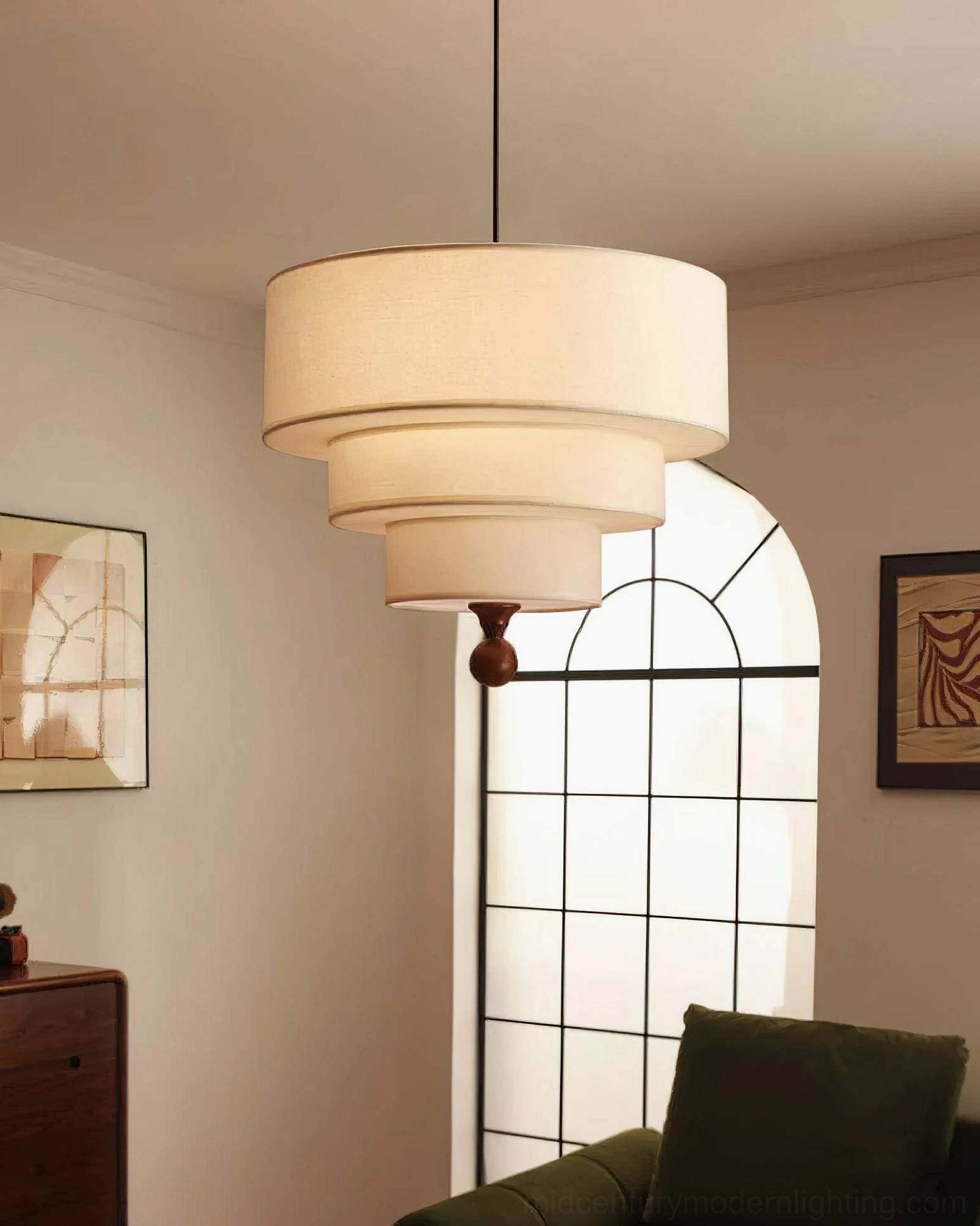 Vanelia all-white tri-tier pendant lamp glowing warmly in cozy living room with arched window and sofa, soft diffused light from five E27 bulb configuration