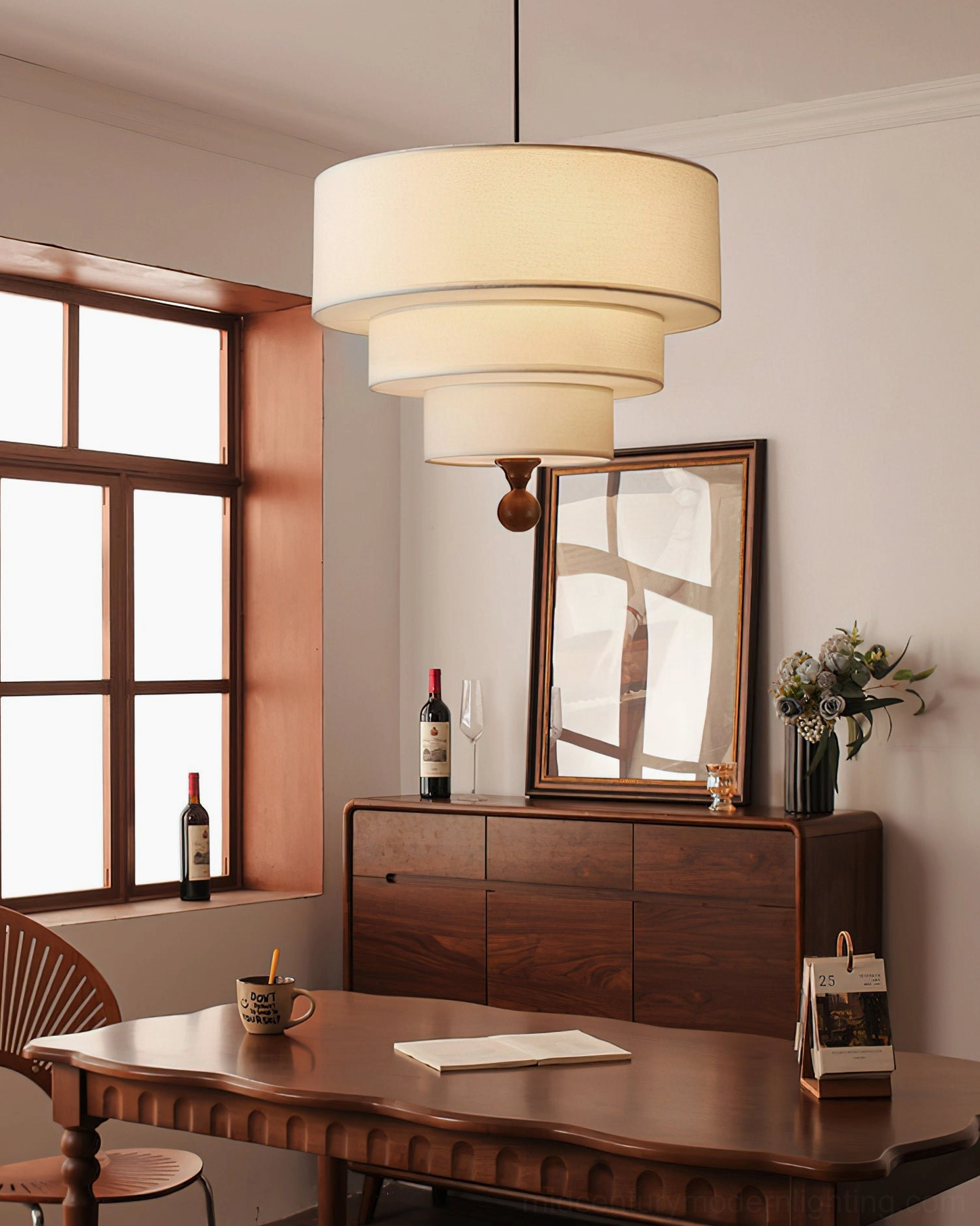 Vanelia all-white tri-tier pendant lamp suspended above wooden dining table and cabinet, warm glow illuminating vintage neutral dining room setting