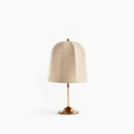 Vanna mid-century modern table lamp with brass base and cloche linen shade, studio front view on white background