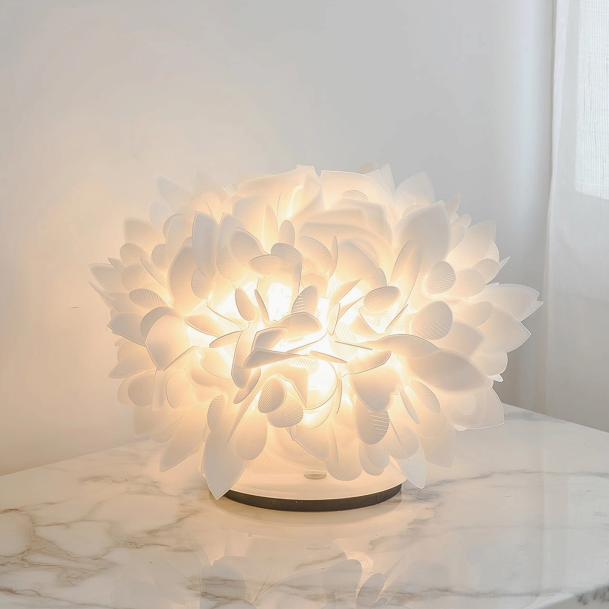 Illuminated Veli Foliage table lamp on marble bedside surface casting warm ambient light