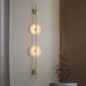 Modern vertical alabaster wall lamp installed in contemporary residential space above console table with warm minimalist lighting effect