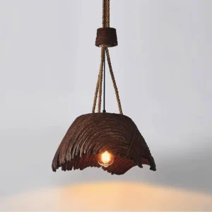 Handcrafted vintage pendant light with warm glowing Edison bulb and textured shade, three-quarter angle