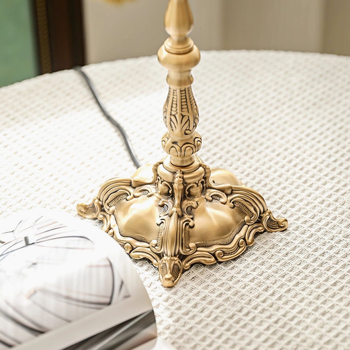 Top-down close-up of antique carved brass lamp base with intricate scrollwork design