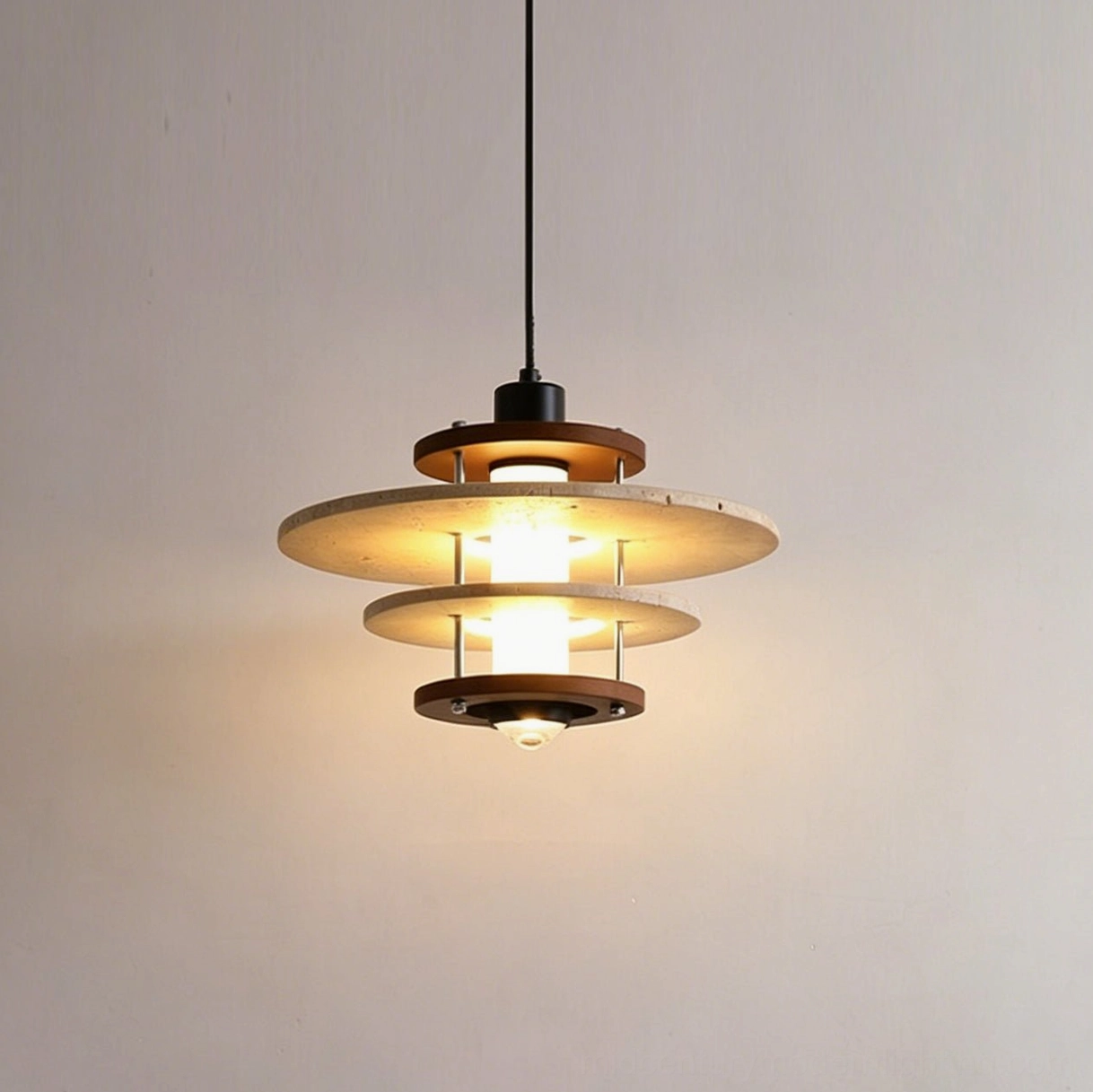 Hanging close-up front view of layered travertine pendant lamp with warm glowing LED light through stone and wood and black metal accents