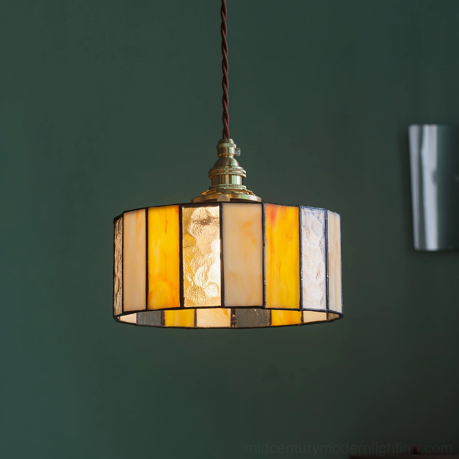 Vintage stained glass pendant lamp with warm amber glass and brass hardware, showcasing classic mid-century modern form
