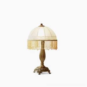 Vintage brass tassel flower table lamp with frosted glass shade and beaded fringe trim, studio front view on white background