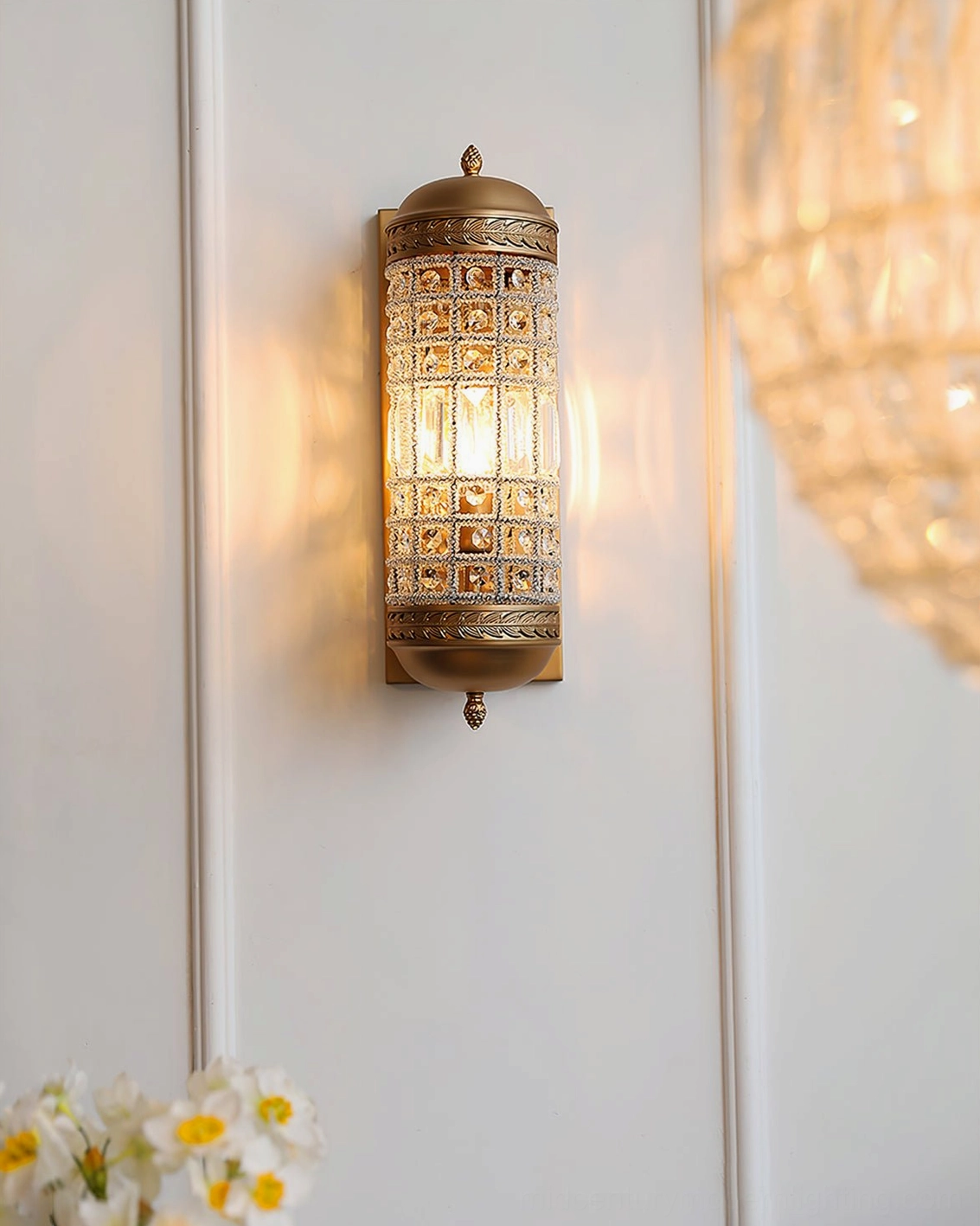 Gold wall sconce with warm glowing light and vintage brass tone in minimalist home interior