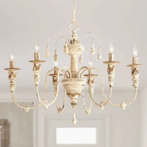 Distressed white candelabra chandelier hanging in elegant home entryway with pendant details