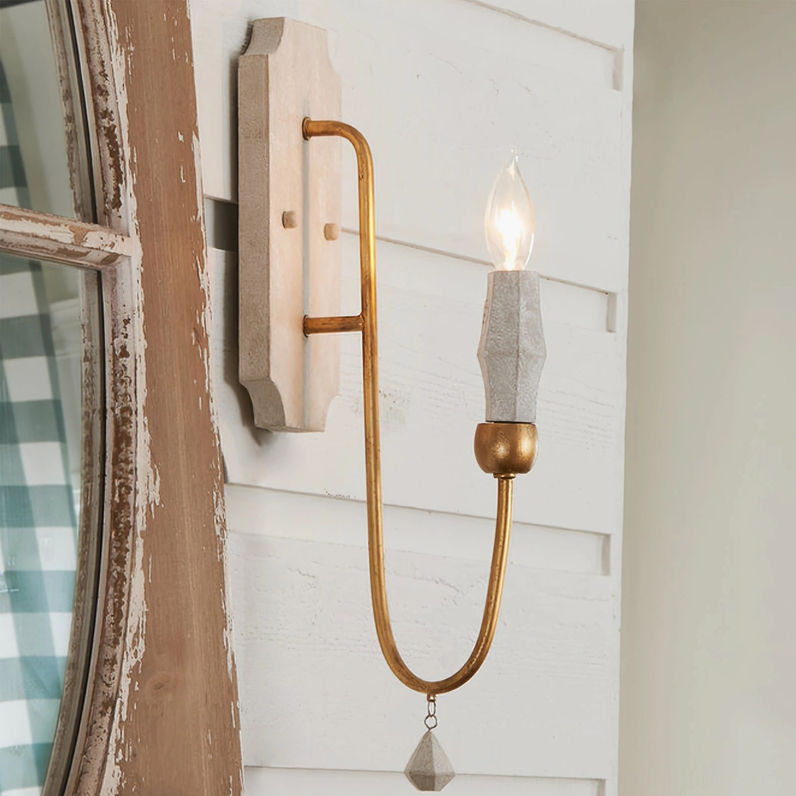 Wood backplate candle sconce with gold metal arm and crystal accent on entryway shiplap wall