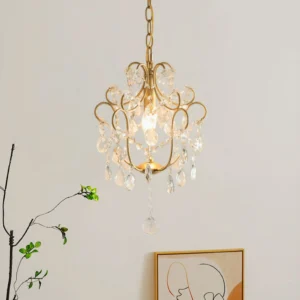 Side angle view of vintage gold crystal chandelier pendant showing detailed metal scrollwork and hanging crystal droplets in minimalist interior setting