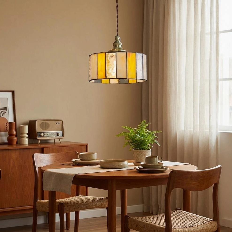 Stained glass drum pendant lamp in casual dining space with vintage radio and wooden furniture creating warm retro ambiance