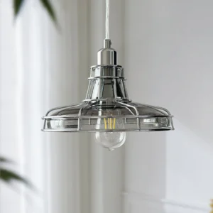 Williston industrial pendant with polished silver hardware and exposed vintage filament bulb in bright daylight near window