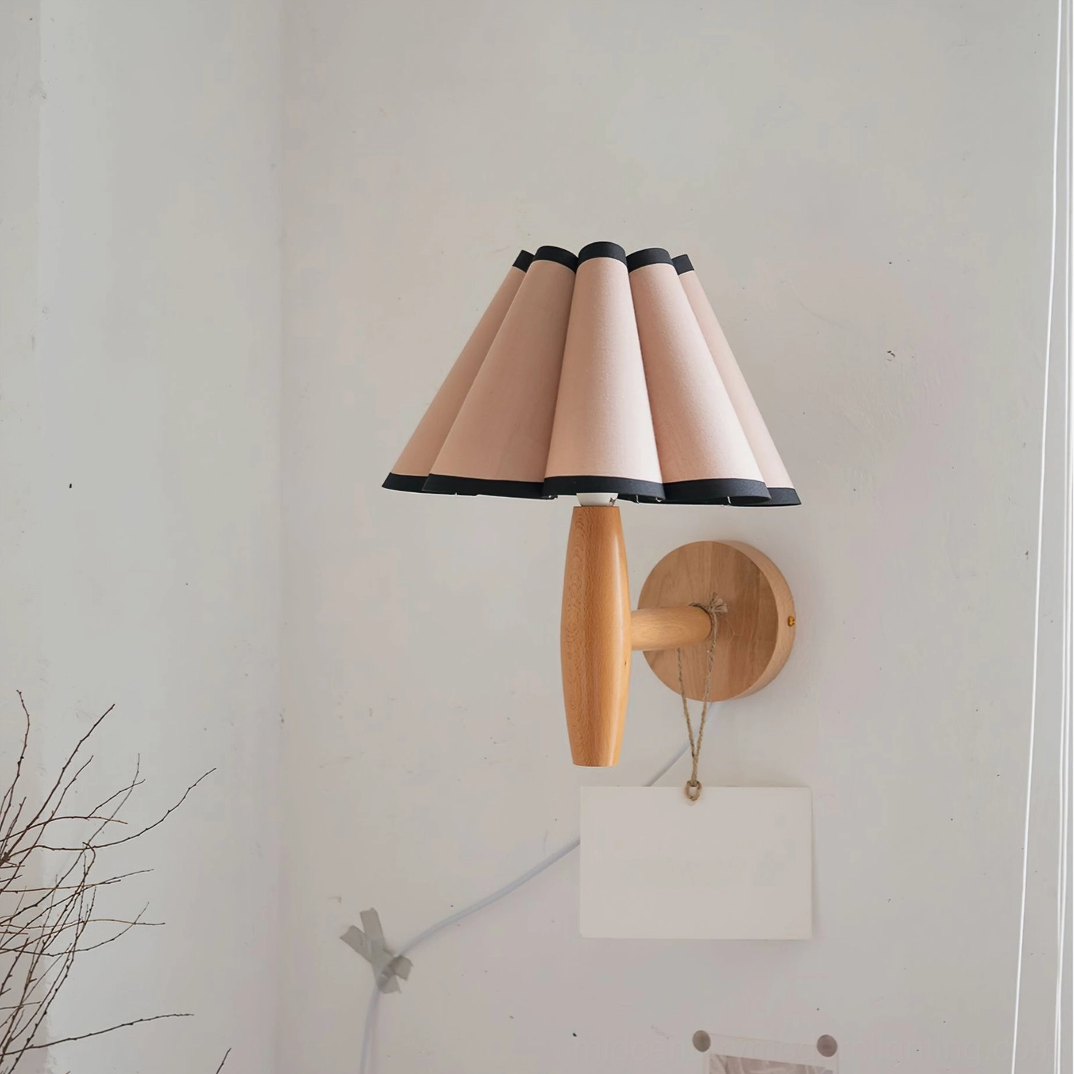 Vintage fluted plug-in wall lamp with pink pleated shade mounted on bedroom wall