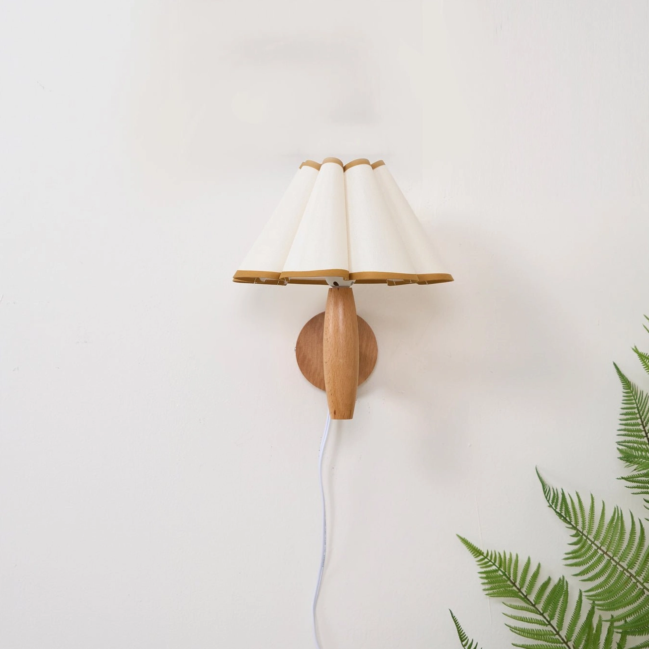 Studio lighting detail of vintage fluted wall lamp with white pleated shade and gold edge trim