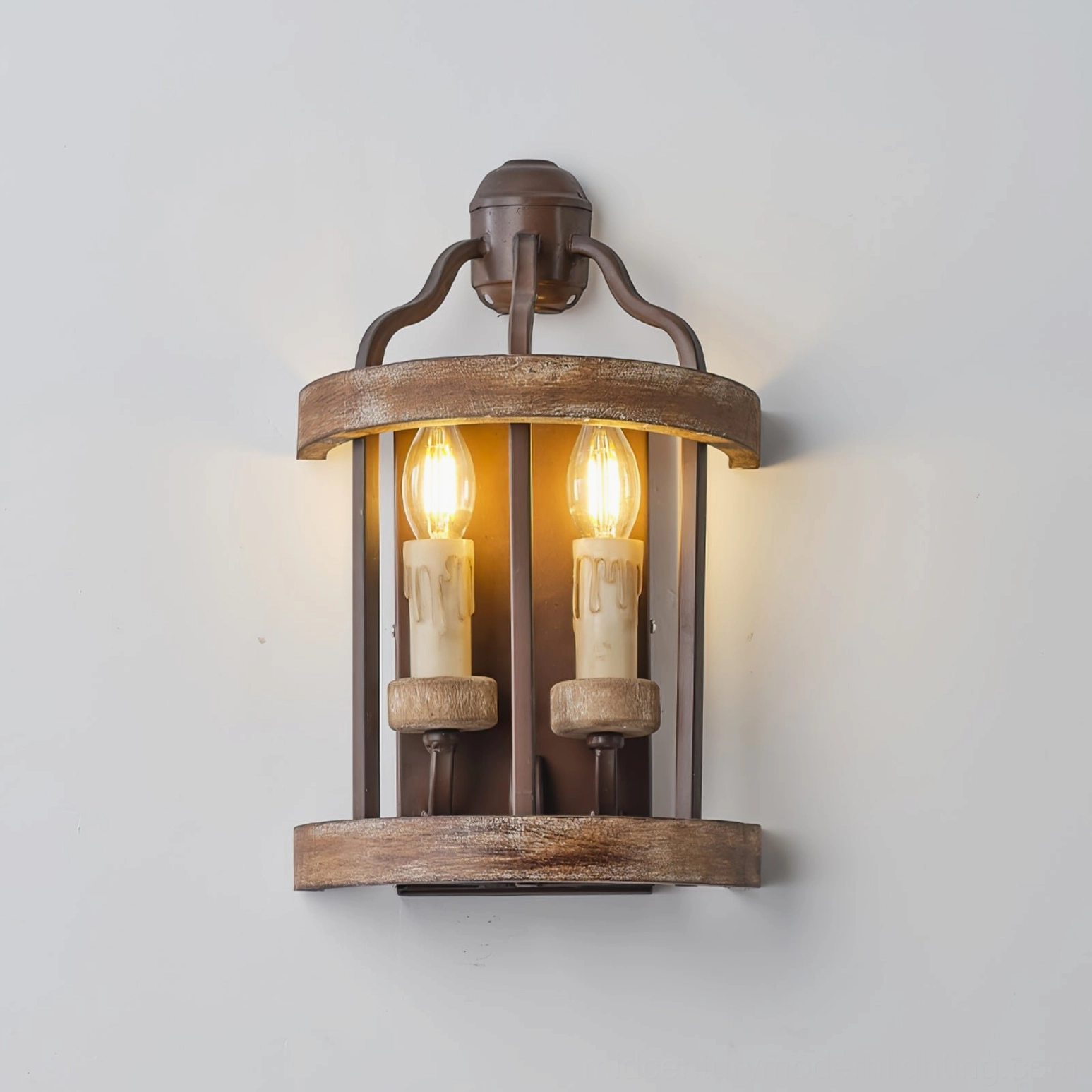 Vintage lantern-style double candle wall sconce with brown wood and metal details on white background