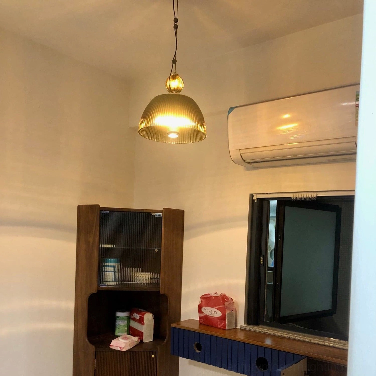 Vintage ribbed pendant lamp creating warm intimate lighting in contemporary styled interior space