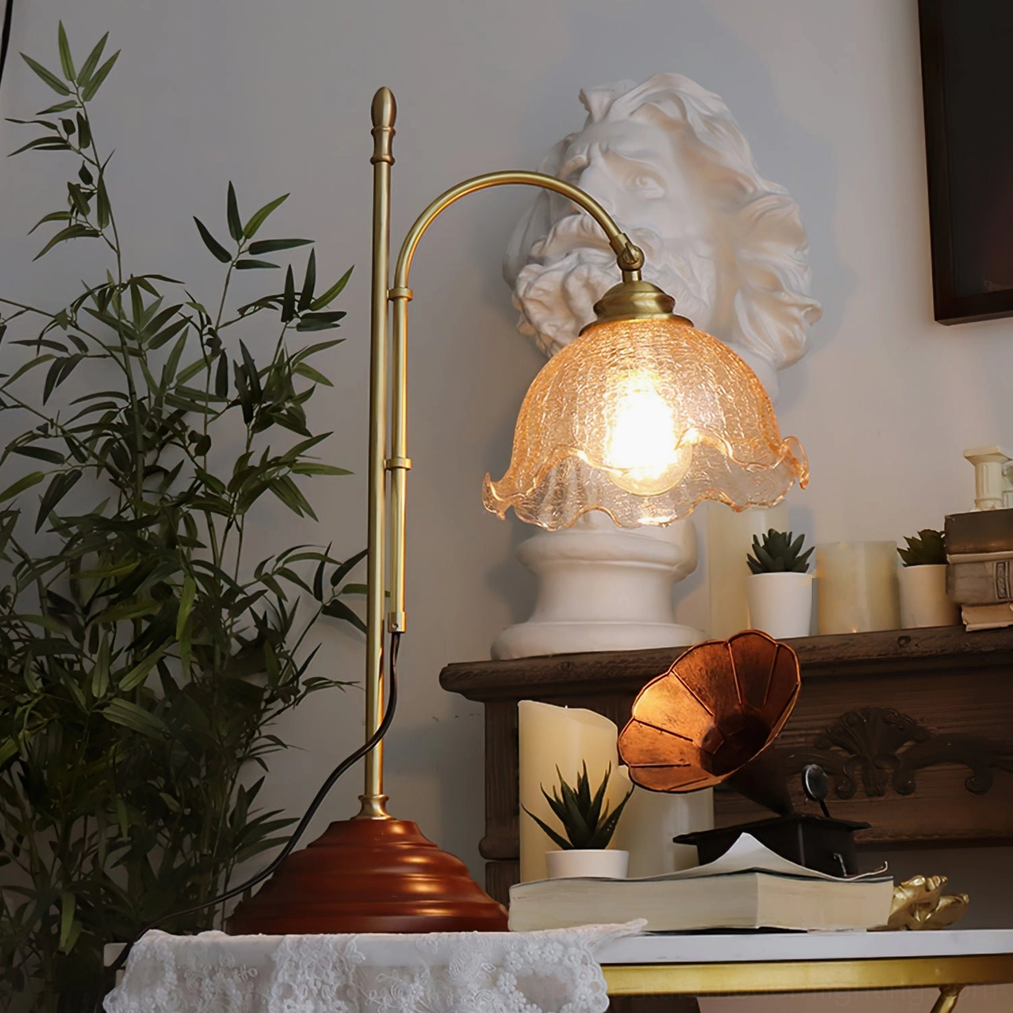 Lit vintage lamp providing soft ambient lighting in studio space with sculpture and wall art