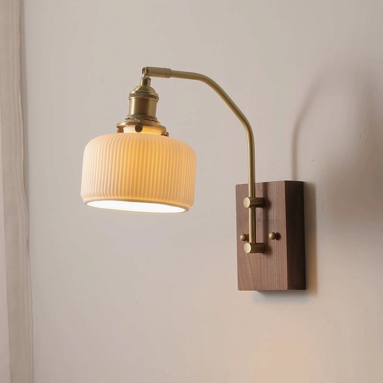 Vintage wall lamp with warm glowing Edison bulb, brass curved arm, and walnut wood base mounted on indoor wall